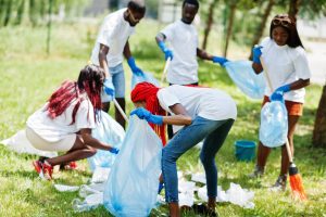 group of happy african volunteers with garbage bags cleaning are